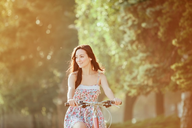 The young girl with bicycle in park