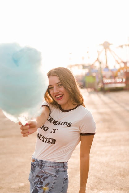 Free photo young girl with cotton candy in the amusement park