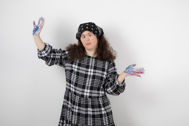 Young girl with down syndrome showing colors and standing. 