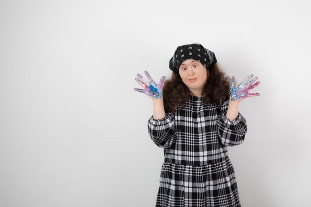 Young girl with down syndrome showing colors on white. 