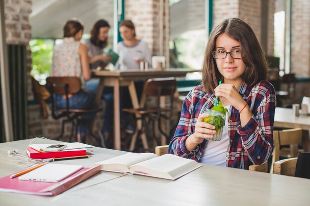 Young girl with drink studying