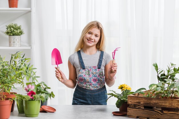 Young girl with equipment in greenhouse