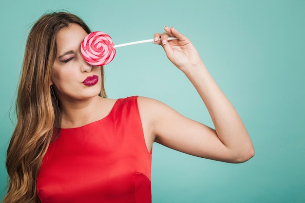 Ragazza con un lecca-lecca sul suo occhio