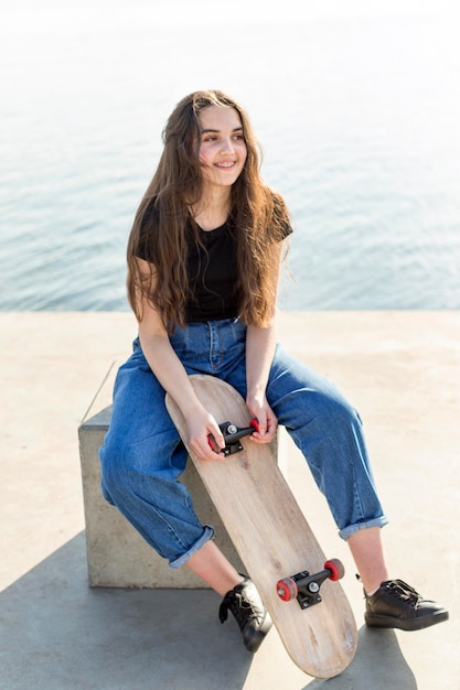 Young girl with long hair holding her skateboard