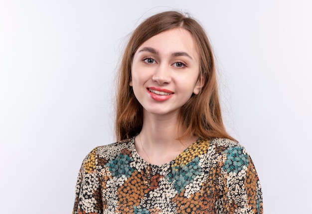 Giovane ragazza con i capelli lunghi che indossa abiti colorati guardando la telecamera sorridente positivo e felice