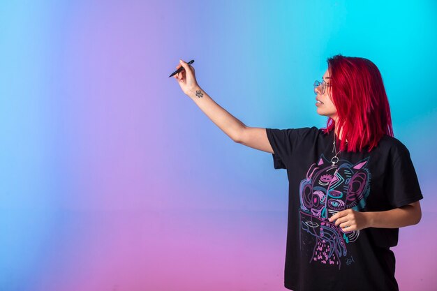 Young girl with pink hairs holding a pen. 