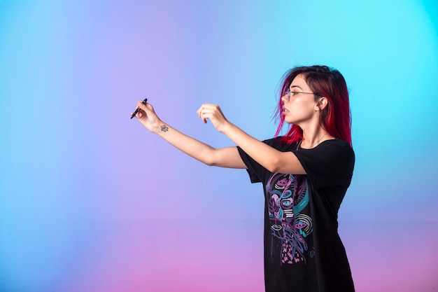 Young girl with pink hairs holding a pen.