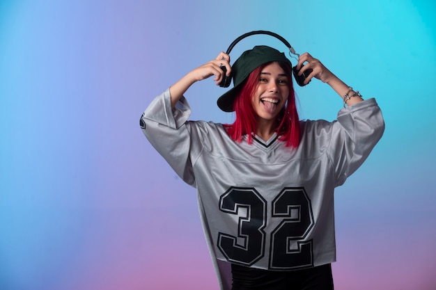 Free photo young girl with pink hairs wearing headphones.