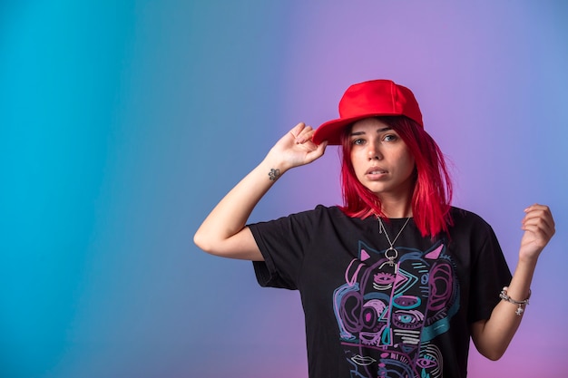 Young girl with pink hairs wearing a red cap. 