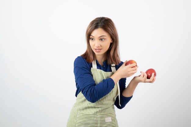 young girl with red apples trying to get from someone.