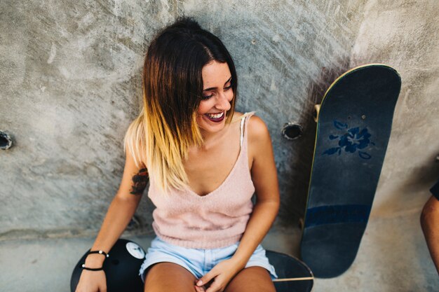 Young girl with skateboard laughing 