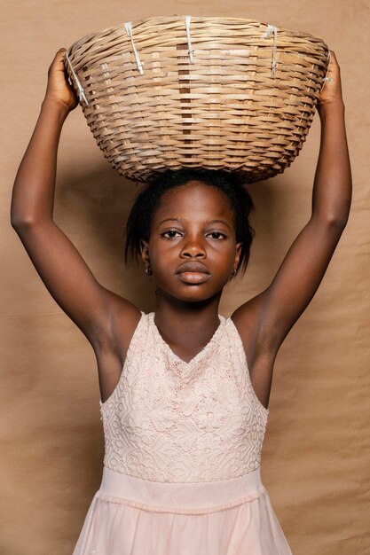 Young girl with straw basket on her head