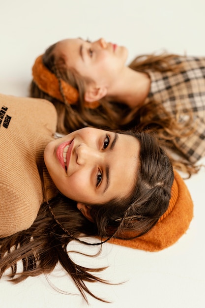 Young girlfriends laid on floor