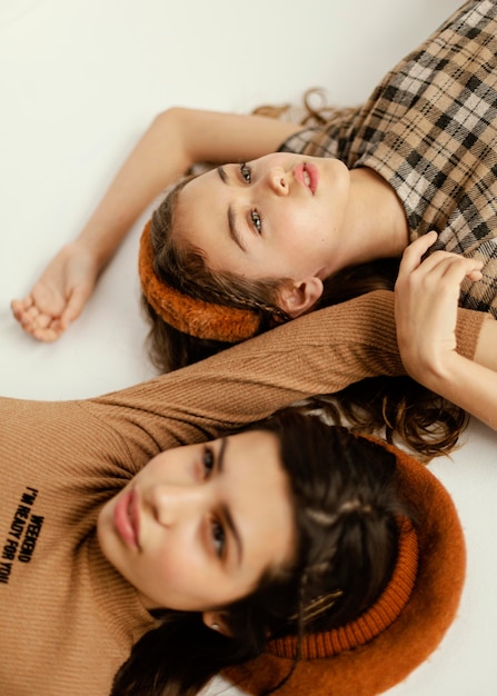 Free photo young girlfriends laid on floor