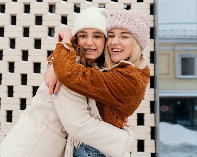 Young girlfriends outdoor hugging