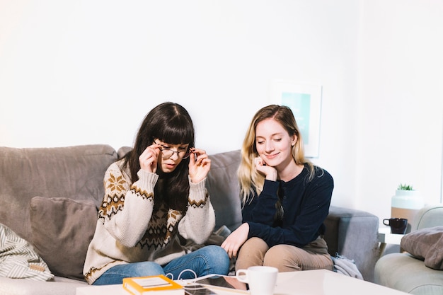 Free photo young girls chilling on sofa at home