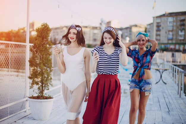 Free photo young girls dressed in modern fashion walking