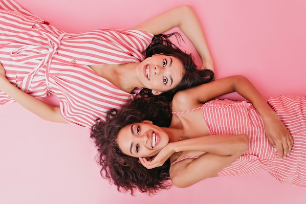 young girls enjoying photo shoot. Ladies in stripped outfits laughing.