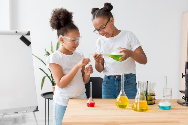 Young girls experimenting with potions while wearing safety glasses