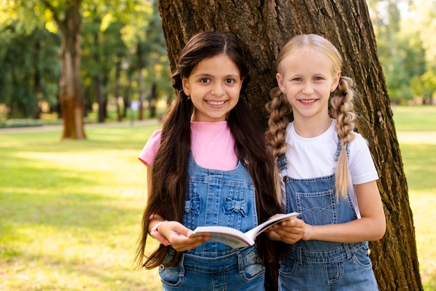 Young girls holding book and looking at camera