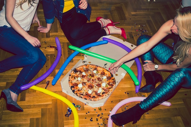 Молодые девушки на вечеринке в пицце