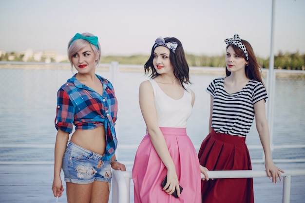 Молодые девушки позируют на перила морского порта