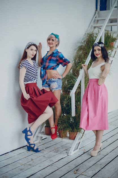 Free photo young girls posing on stairs with plants