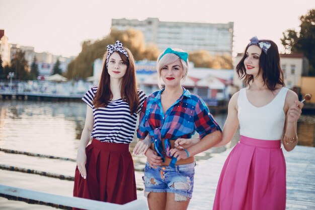 Young girls posing with sea and buildings in background