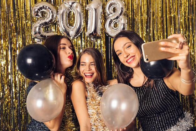 Young girls taking selfie on new year party