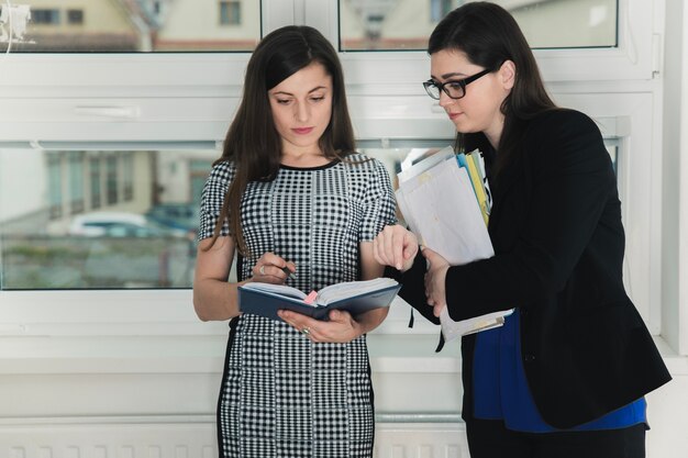 Young girls talking and watching documents