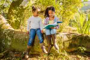 Free photo young girls on tree reading together