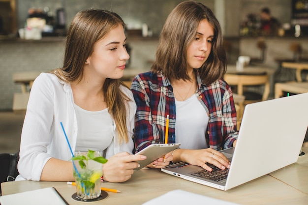 Free photo young girls watching laptop together