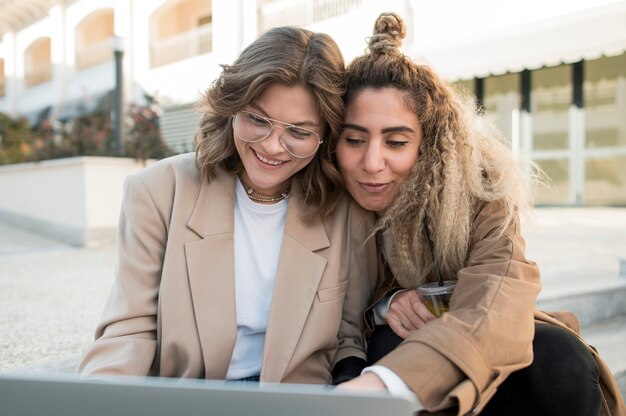 Free photo young girls watching something on laptop