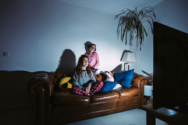 Young girls with dog watching TV