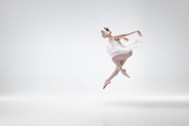 Молодая изящная балерина на фоне белой студии