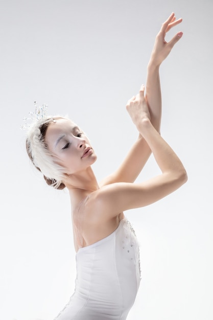 Free photo young graceful ballerina on white studio background