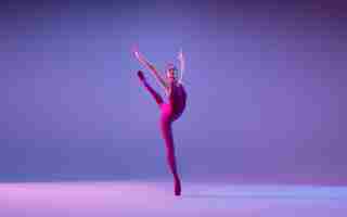 Free photo young and graceful ballet dancer isolated on purple studio background in neon light