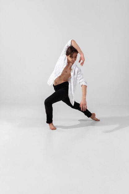 Young and graceful ballet dancer in minimal black style isolated on white