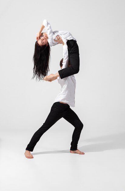 Young and graceful ballet dancers in minimal black style isolated on white