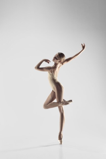 젊은 우아한 여성 발레 댄서 또는 흰색 스튜디오에서 춤을 추는 클래식 발레리나. 뾰족한 신발에 백인 모델
