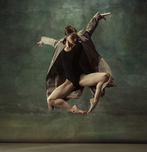 Молодая изящная нежная балерина на темной студии