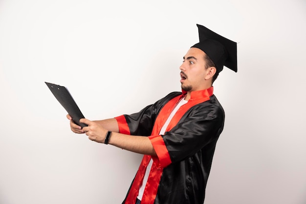 Foto gratuita giovane studente laureato il suo diploma su bianco.