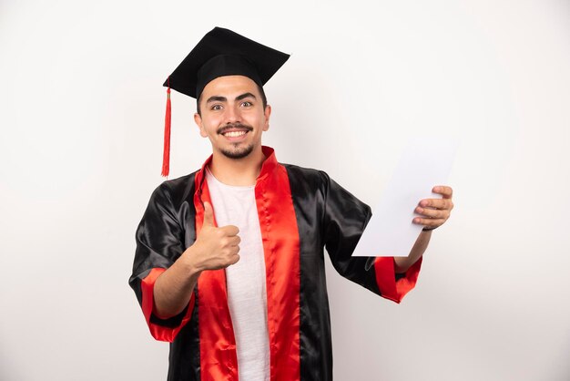 Young graduate student making thumbs up on white.