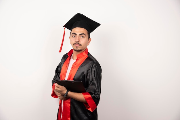 Young graduate student with diploma on white.