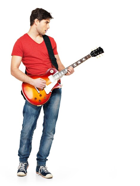 若いギタリストは明るい感情でエレキギターを弾き、白で隔離