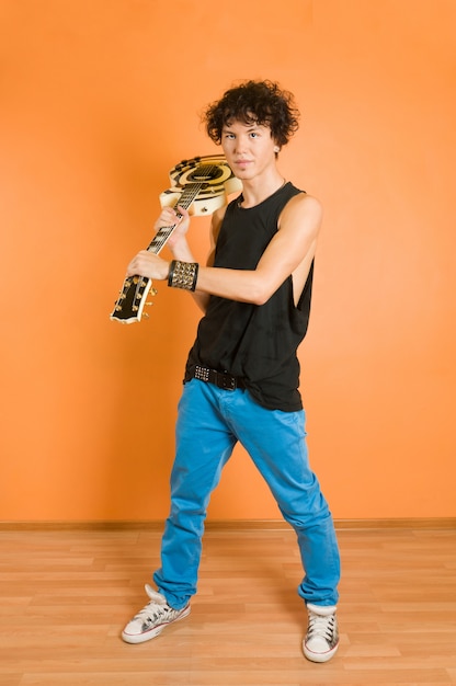 Young guitarist at vivid background