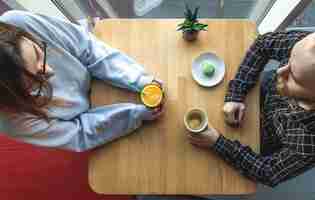 無料写真 ジュースとコーヒーの上面図とカフェのテーブルで若い男と女