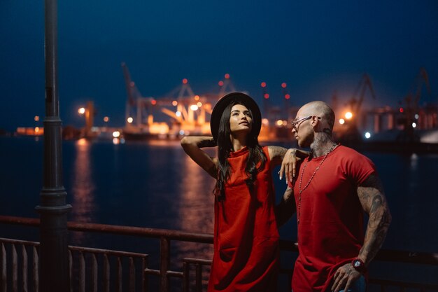 Young guy and beautiful girl on the background of the night port