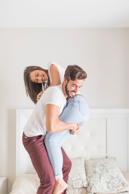 笑っている女性を運ぶ若い男