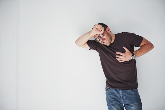 A young guy in casual clothes holds on to the heart and the head